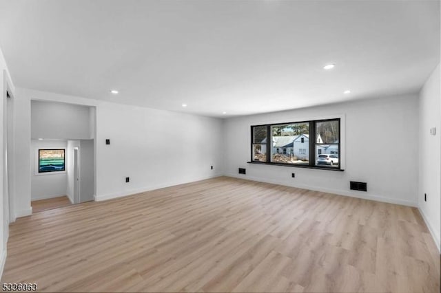 unfurnished living room with a wealth of natural light and light wood-type flooring