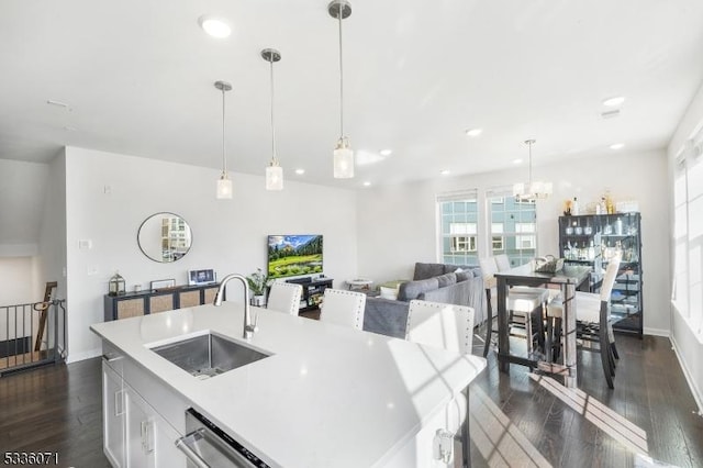 kitchen featuring white cabinetry, an island with sink, decorative light fixtures, sink, and stainless steel dishwasher