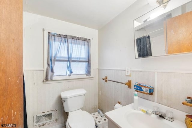 bathroom featuring vanity, walk in shower, and toilet