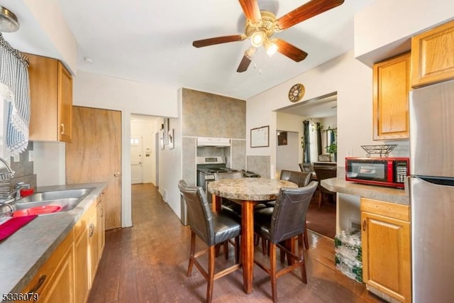 kitchen featuring sink, stainless steel refrigerator, ceiling fan, dark hardwood / wood-style floors, and tasteful backsplash