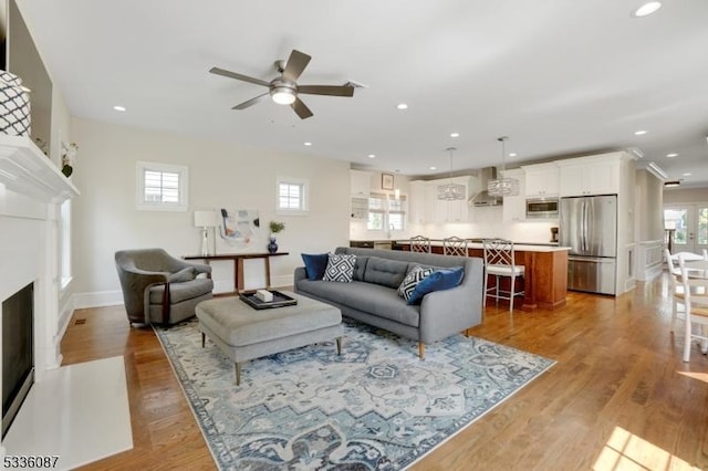 living room featuring light hardwood / wood-style floors and ceiling fan