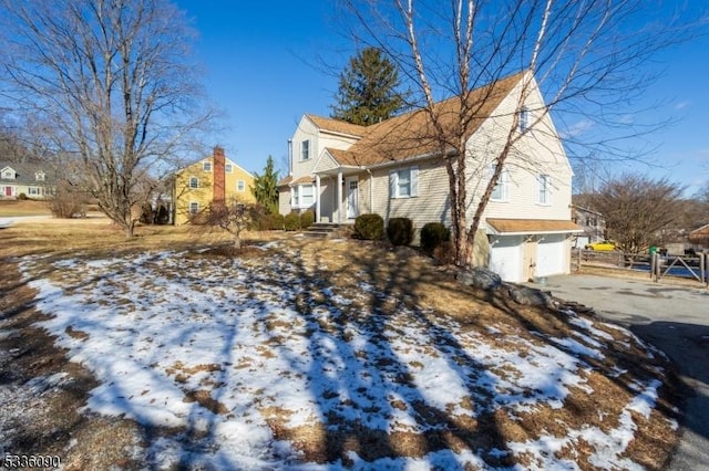 view of snowy exterior featuring a garage