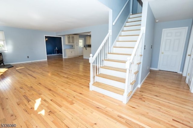 stairs with hardwood / wood-style flooring and a wood stove