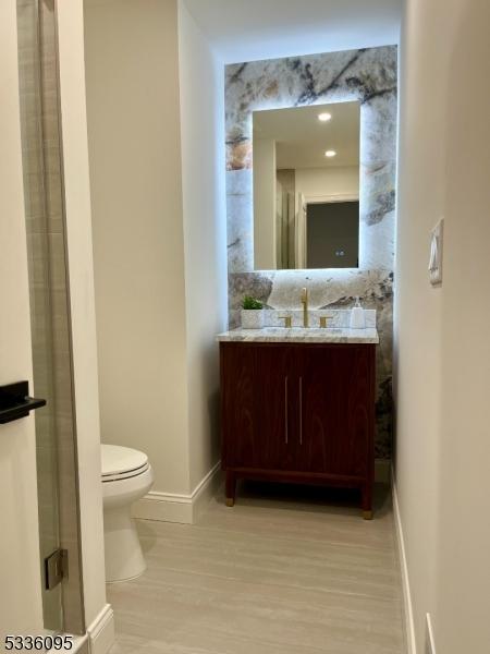 bathroom with vanity, hardwood / wood-style floors, and toilet