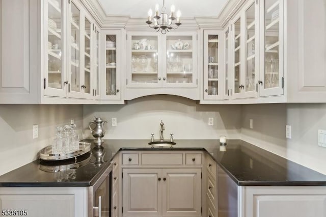 bar with white cabinetry, sink, decorative light fixtures, and a chandelier