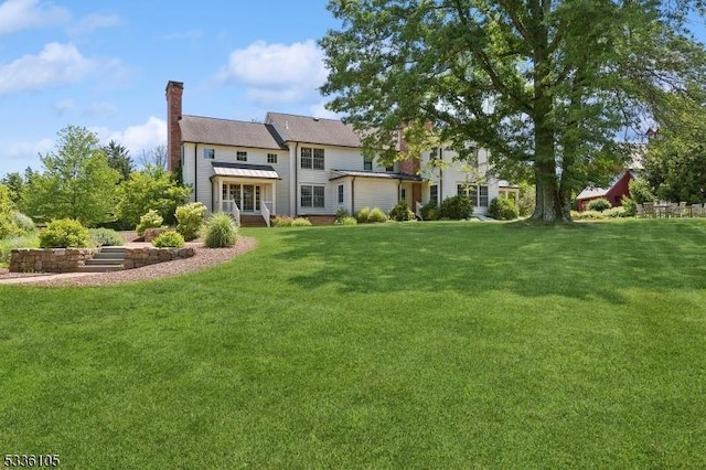 rear view of property with a yard