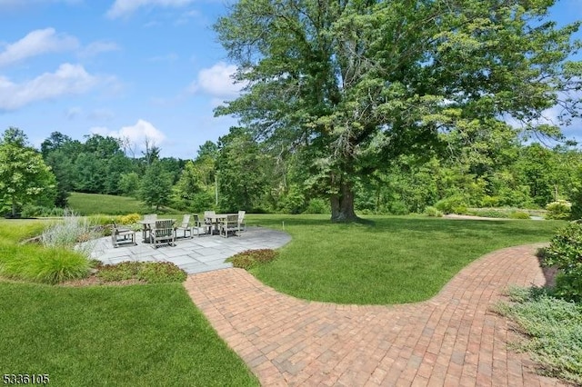 view of home's community featuring a yard and a patio