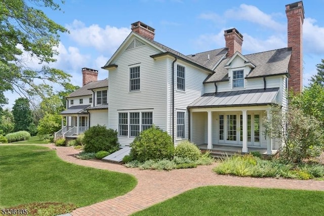 back of house featuring covered porch and a lawn