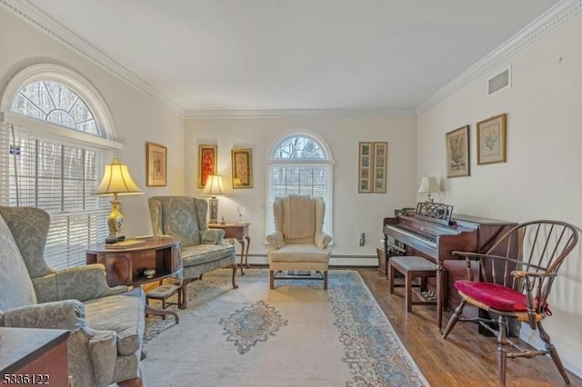 sitting room with ornamental molding, hardwood / wood-style floors, and baseboard heating