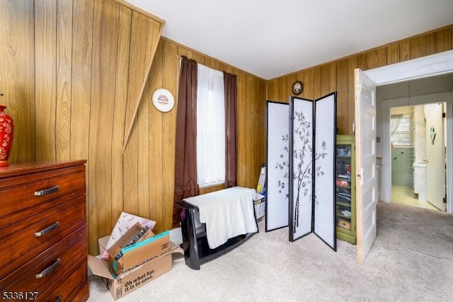 carpeted bedroom with multiple windows and wooden walls