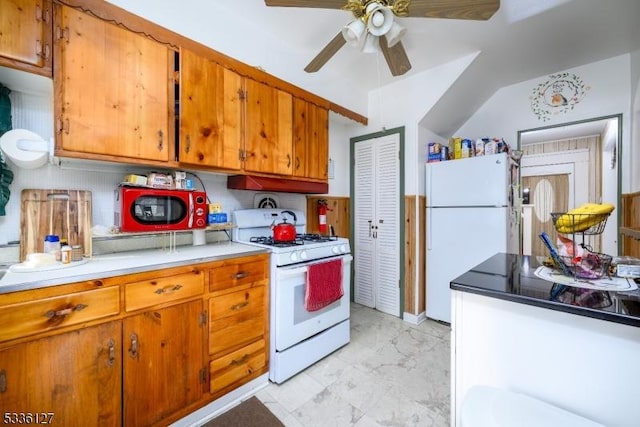 kitchen with ceiling fan, white appliances, and vaulted ceiling