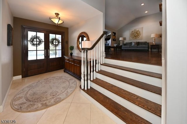 tiled foyer featuring french doors and vaulted ceiling