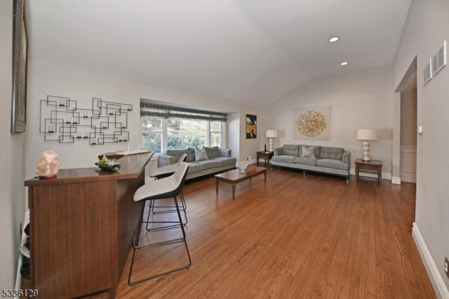 living room featuring lofted ceiling and hardwood / wood-style floors