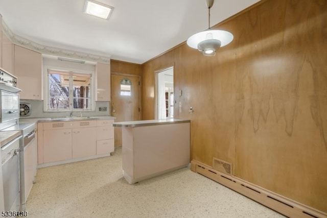 kitchen featuring sink, hanging light fixtures, baseboard heating, kitchen peninsula, and crown molding