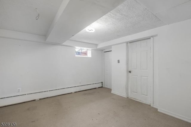 basement with a baseboard heating unit and a textured ceiling