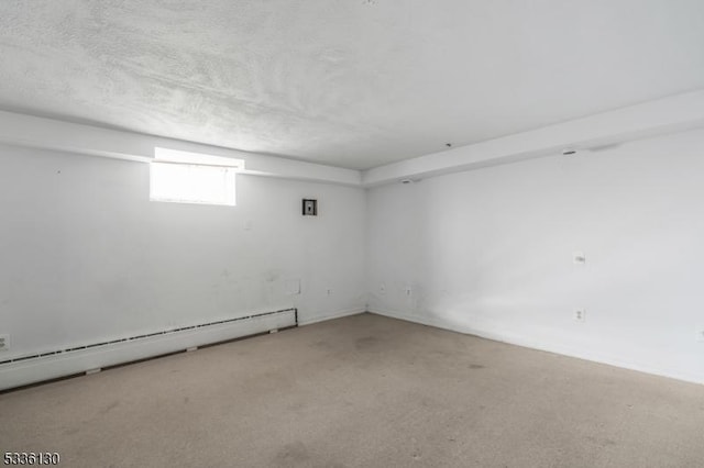 carpeted spare room featuring a textured ceiling and baseboard heating