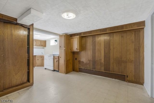 basement with a baseboard heating unit and wooden walls