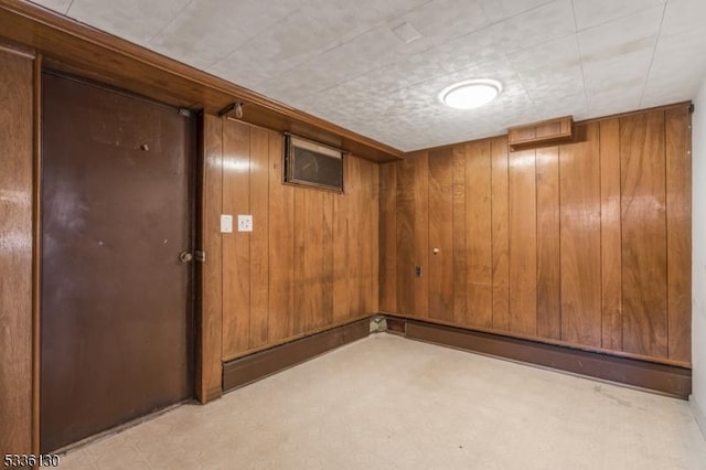 basement with light colored carpet and wooden walls