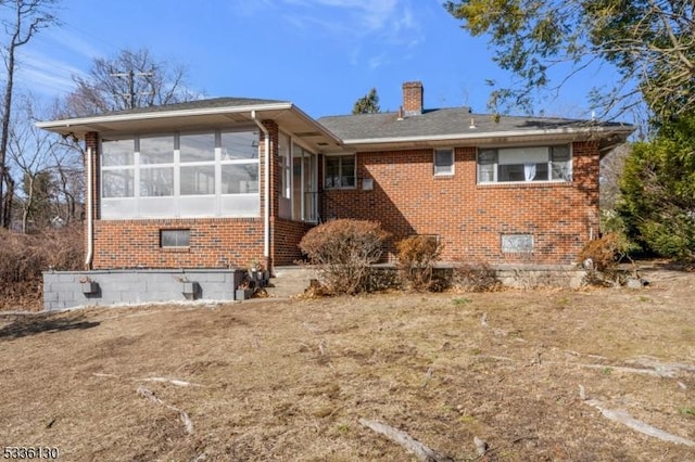 back of house featuring a sunroom and a yard