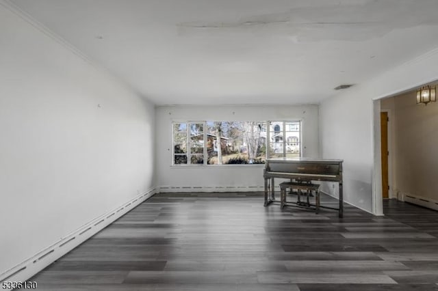 empty room with a baseboard heating unit and dark wood-type flooring