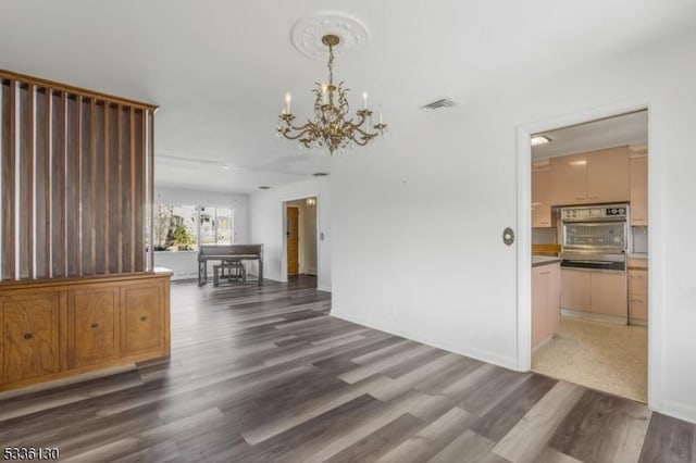 interior space featuring a notable chandelier and dark hardwood / wood-style flooring