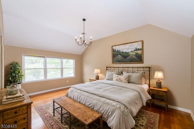 bedroom featuring an inviting chandelier, lofted ceiling, and hardwood / wood-style floors