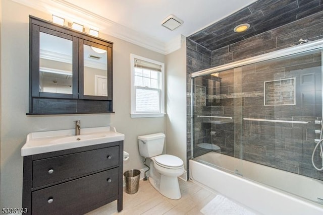 full bathroom with bath / shower combo with glass door, vanity, crown molding, and toilet