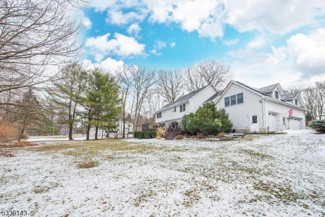 snow covered property featuring a garage