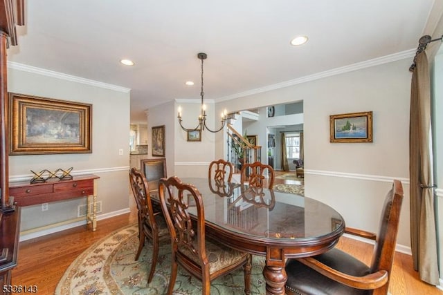 dining space featuring ornamental molding, a chandelier, and light wood-type flooring