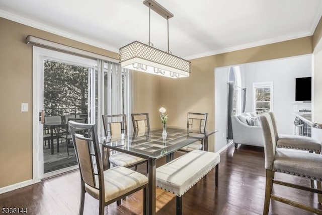 dining area with dark hardwood / wood-style flooring and crown molding