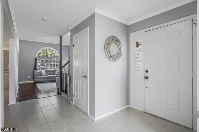 entryway featuring ornamental molding and light tile patterned floors