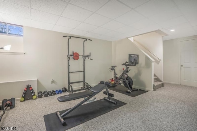 exercise room with carpet and a paneled ceiling