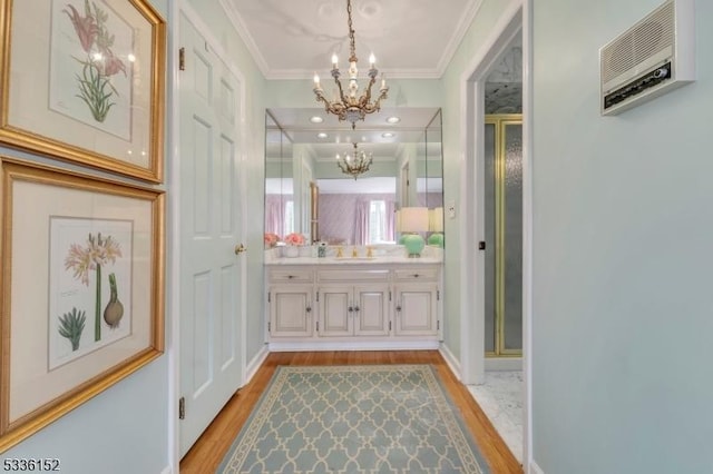 bathroom with hardwood / wood-style flooring, vanity, an enclosed shower, crown molding, and an inviting chandelier