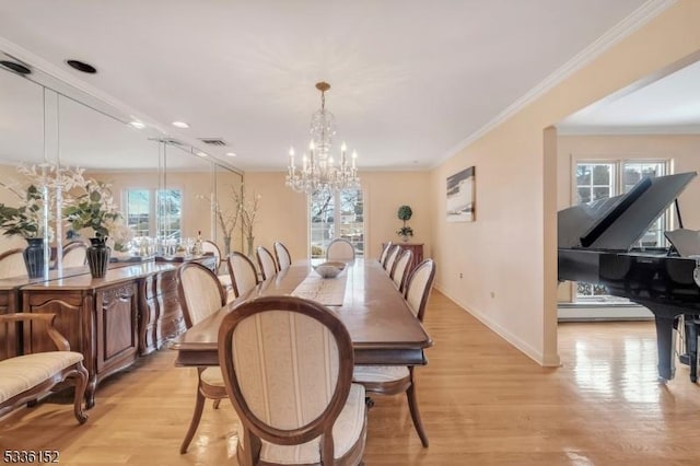 dining room with crown molding, light hardwood / wood-style floors, and a chandelier