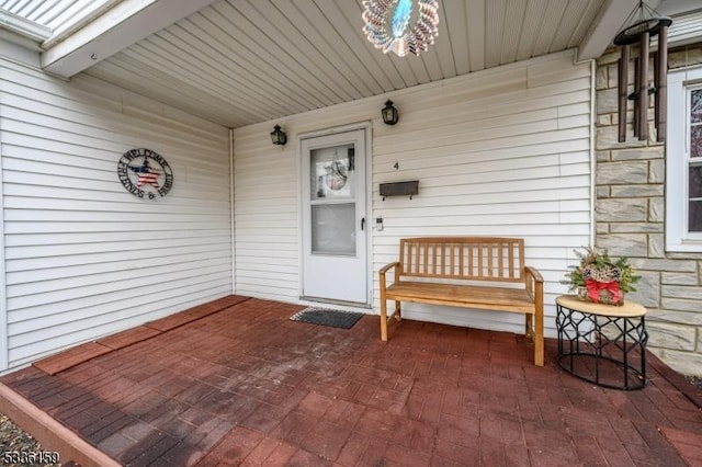 property entrance with covered porch and stone siding