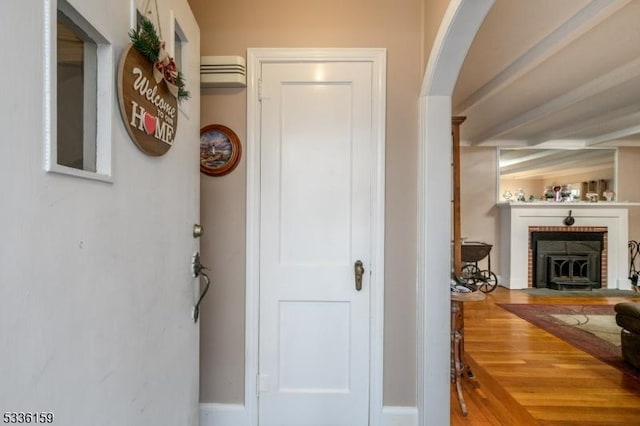 hall featuring wood finished floors and arched walkways