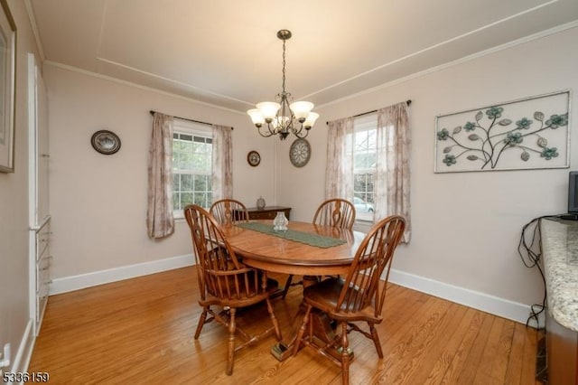 dining space featuring a notable chandelier, baseboards, crown molding, and light wood-style floors