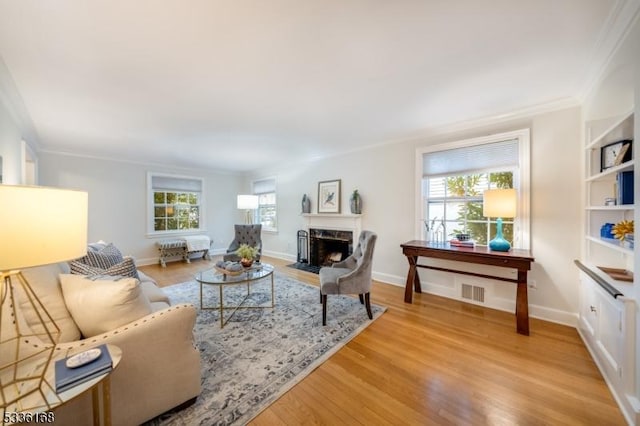 living room with hardwood / wood-style flooring, plenty of natural light, and crown molding