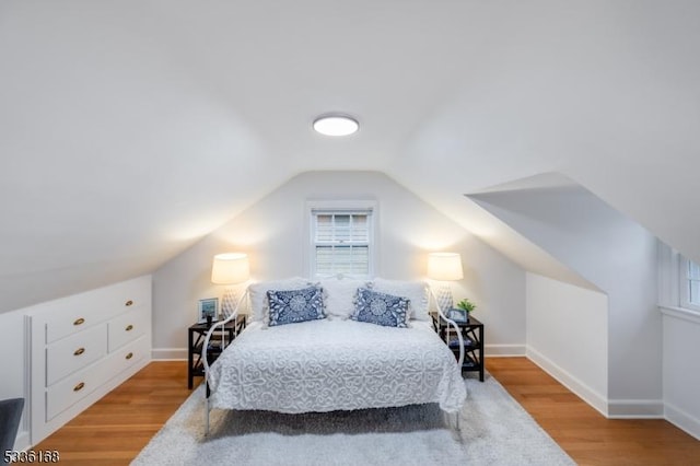 bedroom featuring lofted ceiling and light hardwood / wood-style flooring