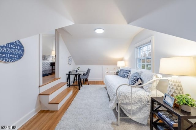 bedroom featuring hardwood / wood-style flooring and lofted ceiling