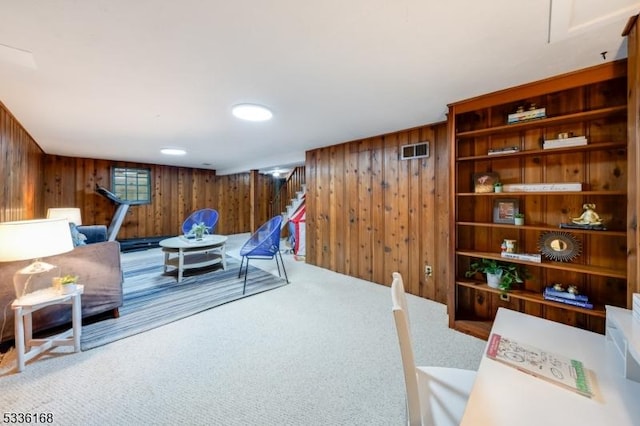 sitting room with carpet floors and wooden walls