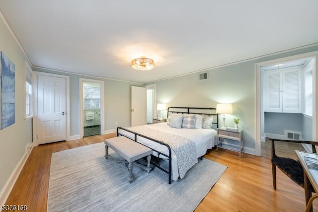 bedroom featuring ornamental molding and light hardwood / wood-style flooring