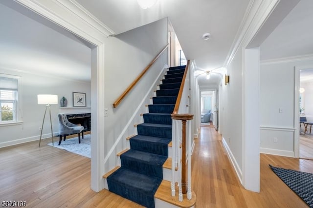 stairway with crown molding and hardwood / wood-style flooring