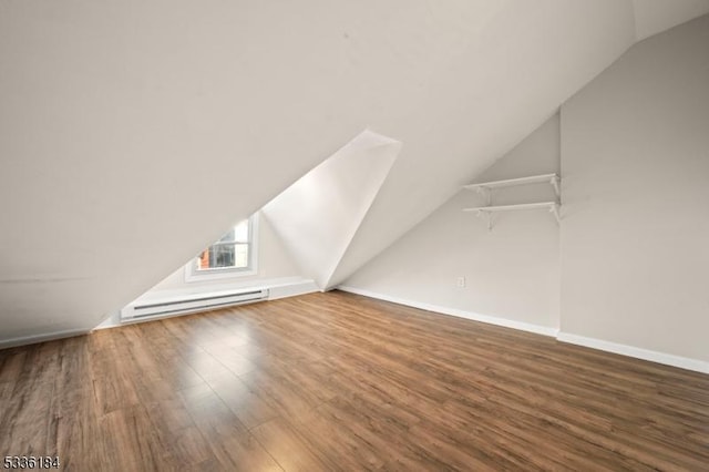 bonus room featuring a baseboard heating unit, hardwood / wood-style flooring, and vaulted ceiling