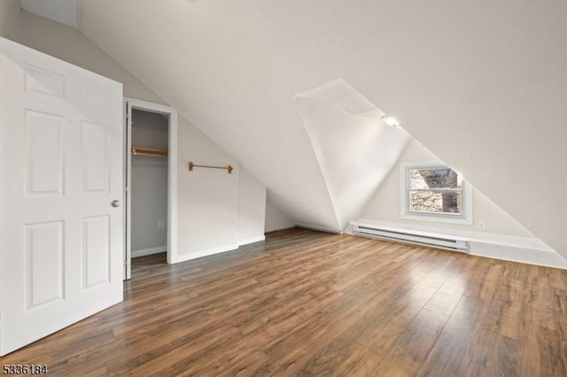 bonus room featuring dark wood-type flooring, lofted ceiling, and a baseboard heating unit