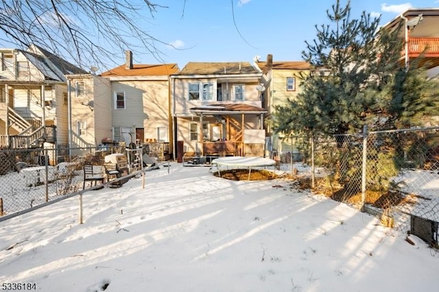 snow covered house with a trampoline