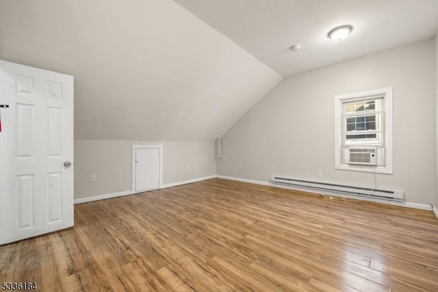 bonus room with vaulted ceiling, hardwood / wood-style floors, cooling unit, and a baseboard heating unit