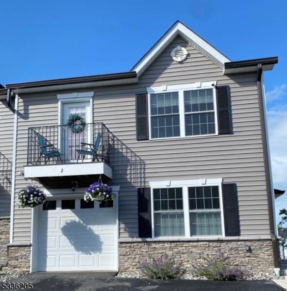 view of front facade featuring a garage and a balcony