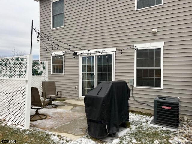 snow covered patio featuring area for grilling and central air condition unit