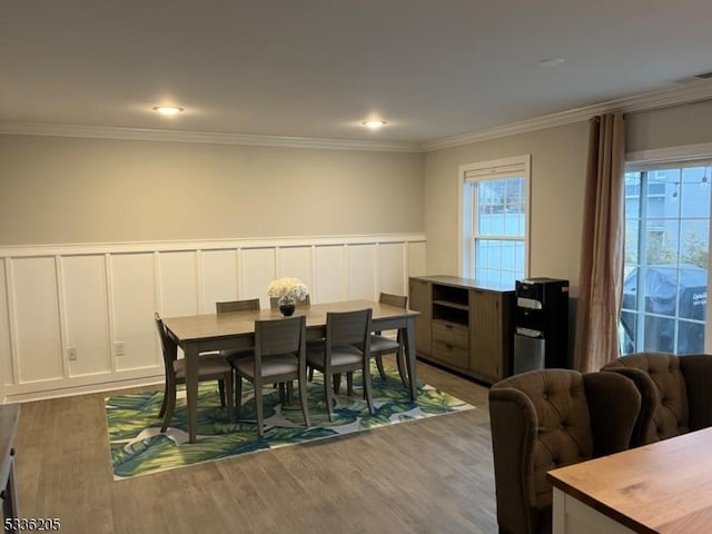 dining area featuring wood-type flooring and ornamental molding